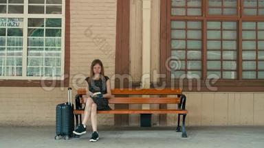 白人妇女正在车站站台等火车，正在看书
